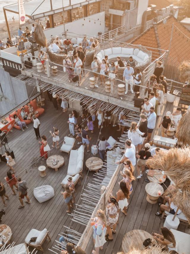 Sol Rooftop in golden-hour light, guests across two open decks
