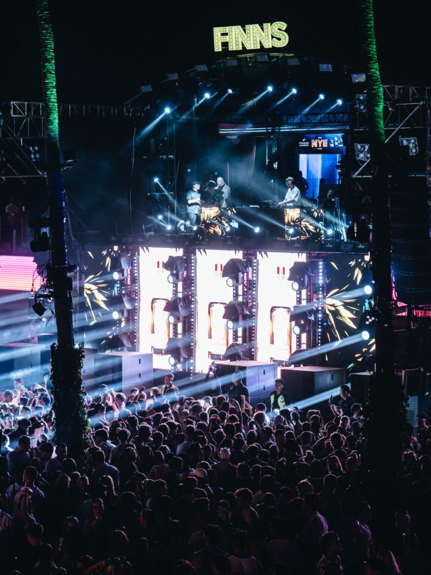 Festival stage with DJ and packed crowd at night